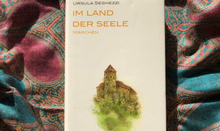 Das Buch "Im Land der Seele" von Ursula Segghezzi. Auf dem Cover steht unter dem Titel "Märchen", darunter ist eine mittelalterliche Burg auf grüner Wiese, umrankt von Blumen, abgebildet, vermutlich ein Aquarell.
